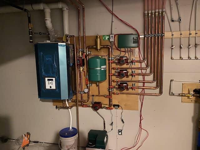 Fire sprinkler system installation featuring overhead sprinkler heads, piping network, and control valves in commercial ceiling space